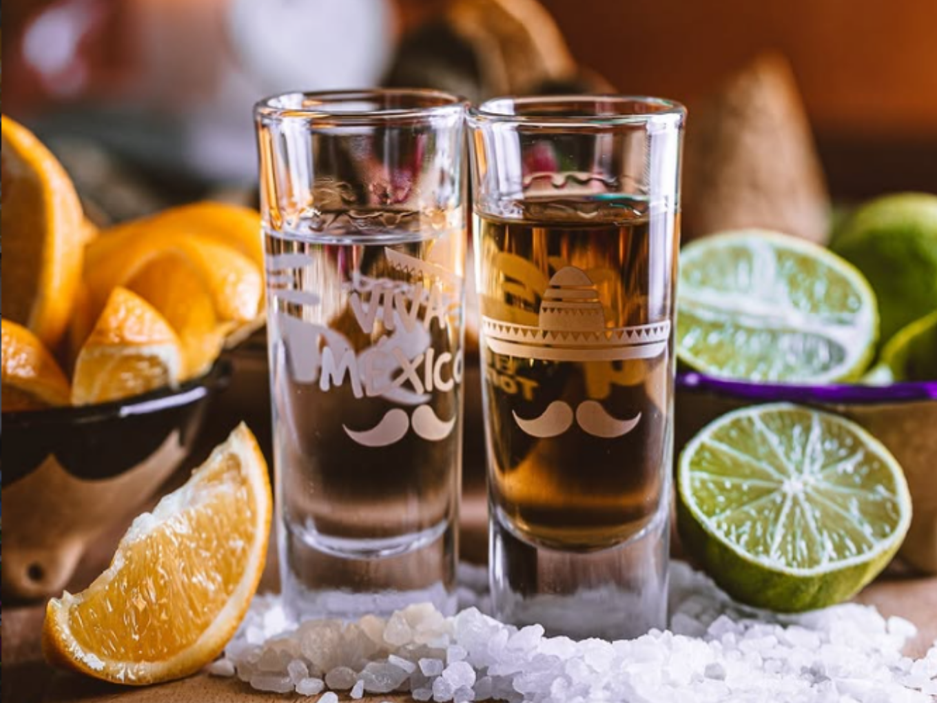 Zwei Tequila-Gläser mit Salz, Limetten und Orangenstücken.