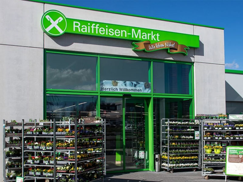 Eingang des Raiffeisen-Markts in Sprockhövel mit Pflanzenverkauf im Außenbereich.