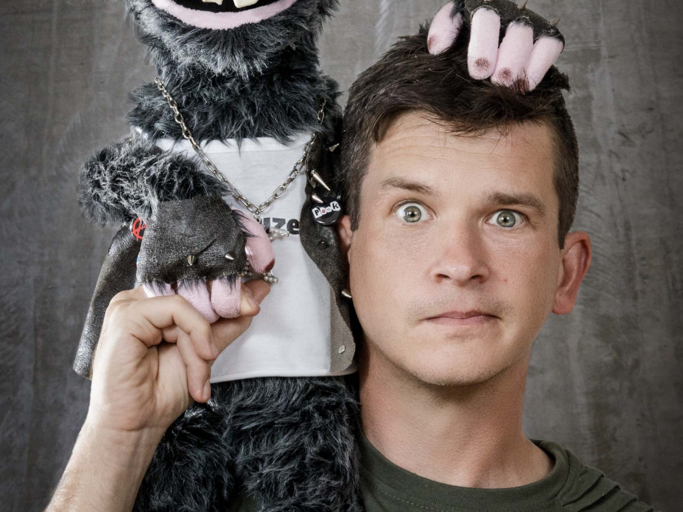 Bauchredner mit Handpuppe, beide schauen in die Kamera.
