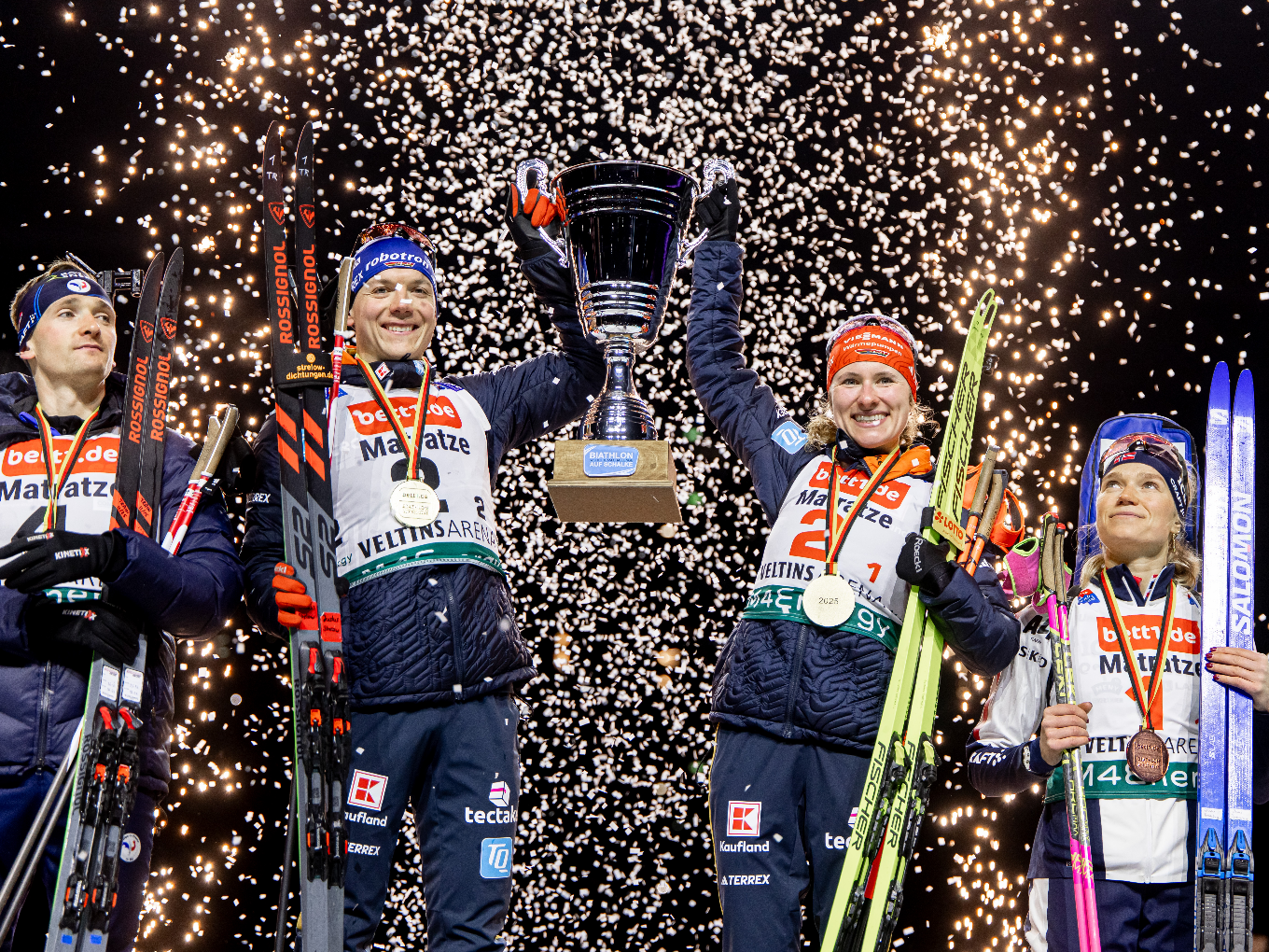 Siegerehrung der Biathlon World Team Challenge mit Pokal, Medaillen und Konfettiregen.