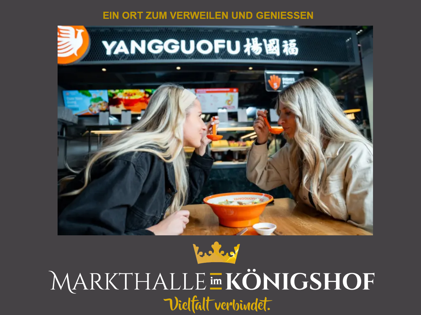 Zwei Frauen essen gemeinsam an einem Tisch vor dem Food-Stand „YANGGUOFU“ in der Markthalle im Königshof.