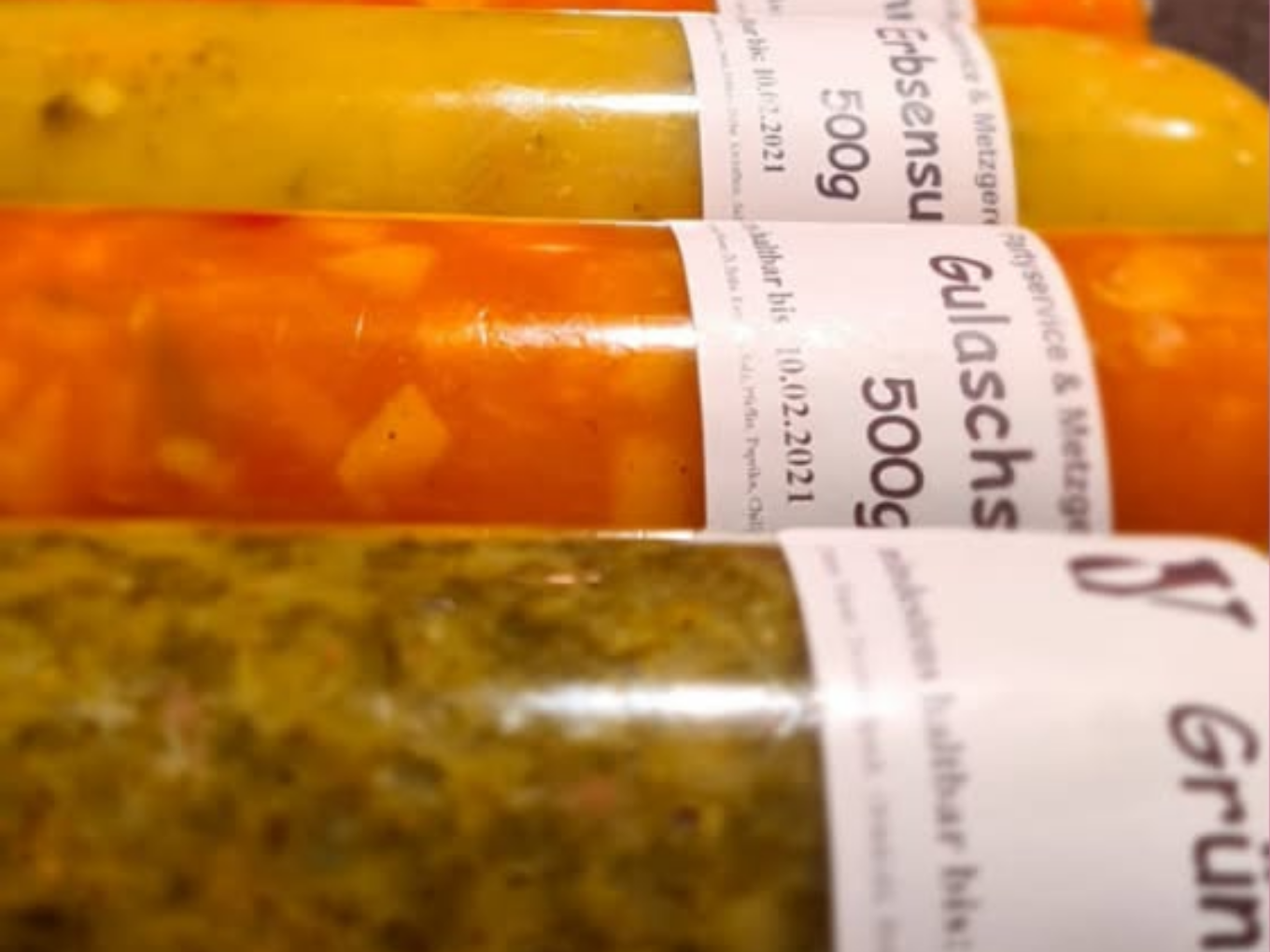Verschiedene abgepackte Suppen und Eintöpfe in Plastikbeuteln, nebeneinander gelegt.