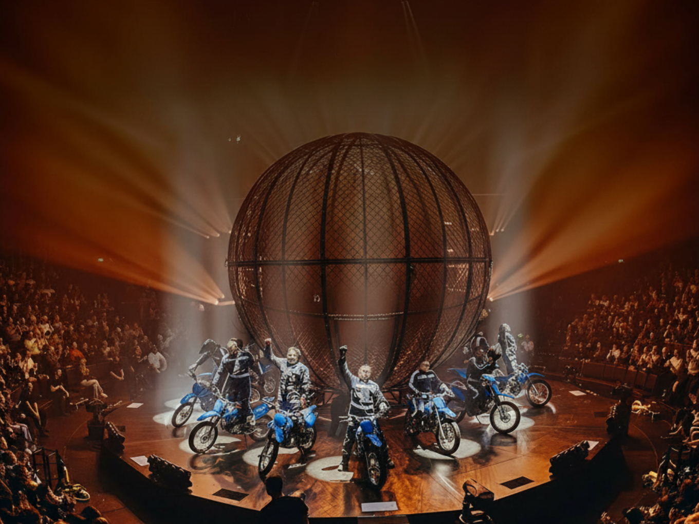 Motorradartisten vor der Stahlkugel bei einer Flic Flac Show